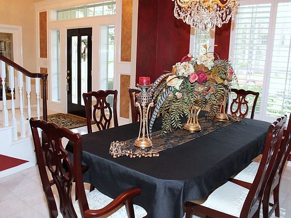 Formal Dining Room also boasts a crystal chandelier, plantation shutters & custom paint.