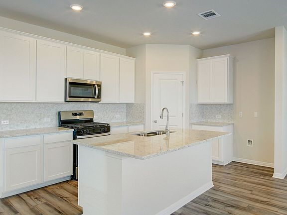 The kitchen features linen-colored cabinets and granite countertops.