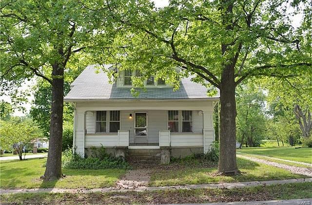 Front of home facing S Locust with covered front porch.