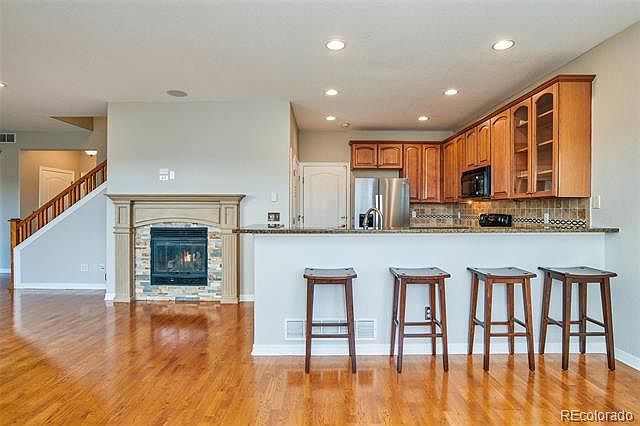 Kitchen with bar seating dining and family room with fireplace