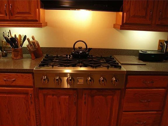 "A professional series cooktop, solid surface counters and raised panel cabinetry. "