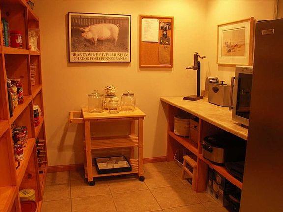 "Pantry equipped with an upright freezer and built in shelving."