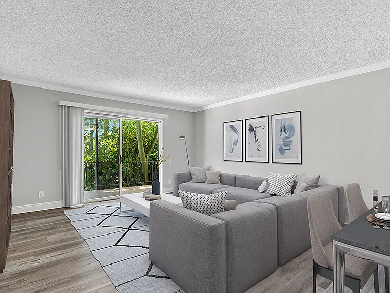 Hardwood floored living room with view of outdoor patio.