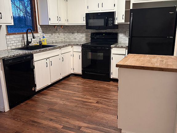 Fully furnished kitchen with microwave, dishwasher, self cleaning smooth top stove, side by side refrigerator and built in cutting board.