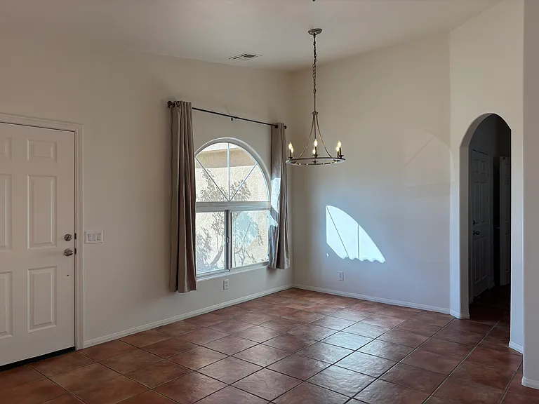Bright entry and dining area with high ceilings, arched details, and plenty of natural light.