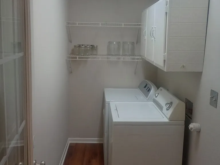 Utility Room is completely remodeled with laminate flooring. Includes washer and gas dryer with utility shelving and cabinets. Pantry located to the right.