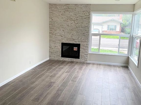 The Living room has a wall to ceiling beautiful stone decorating fireplace. Large corner window to let in plenty of light.