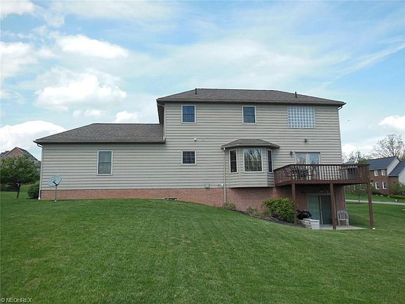 Rear view showing bay window at the breakfast area, rear deck and sliders to the basement.