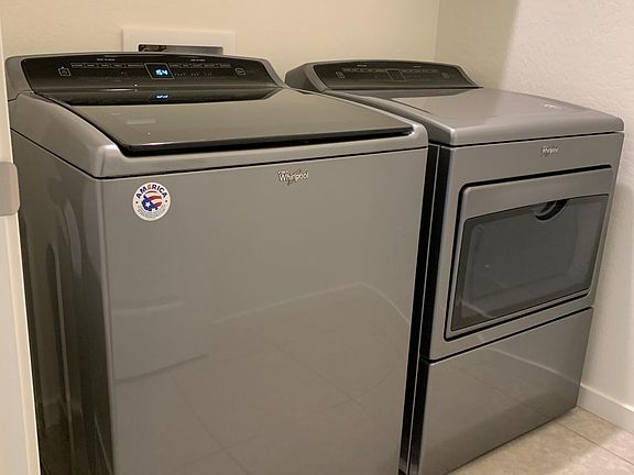Washer and dryer included in separate laundry room.