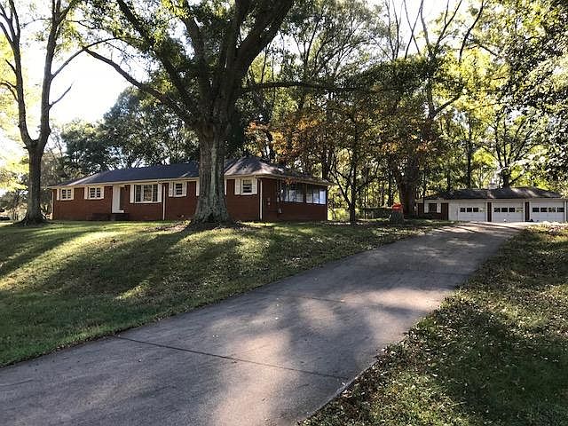 Street view. Paved driveway, 3 car garage with attached shop
