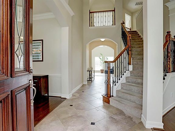 You will enter through the leaded glass and wood front door into the two story entry. The foyer features diagonal tile with marble inserts, view of the curved wrought iron stairwell and very open.