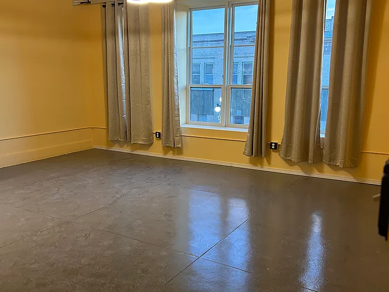 Kitchen/dining room area, with large windows, curtains, and views of the city below. Several available outlets, bay windows, and tile floors.