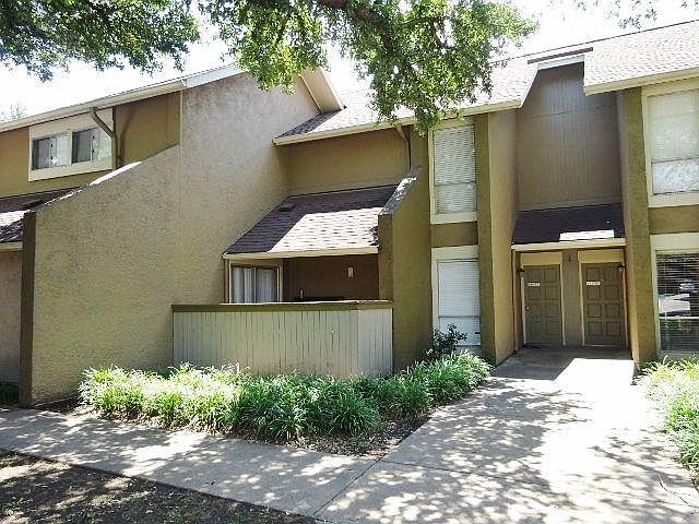 Charming Community Exterior _ Well-maintained buildings with mature trees for shade and curb appeal.