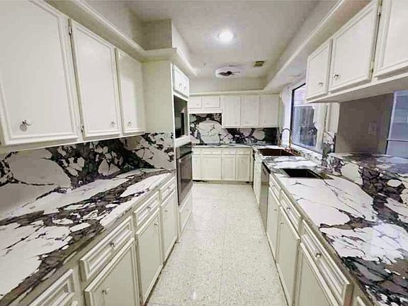 Newly remodeled kitchen with all new appliances, 2 sinks, plenty of cabinets for storage, granite countertops and backsplash. Features a kitchen pass-through with seating.