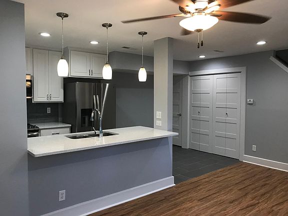 View from living room towards kitchen, dining, and stairwell