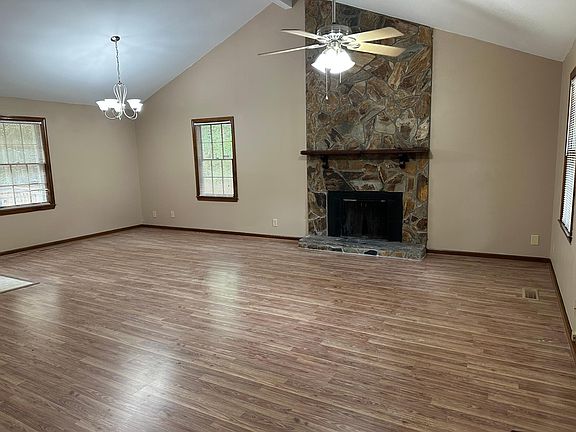 Spacious living room with high ceilings, and stone fireplace