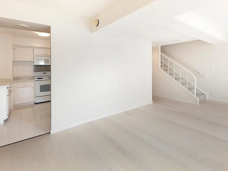 This space leads you to the kitchen area and stairs heading to the loft bedroom. The hardwood floors are extended up to this side, giving you that elegant interior and style.