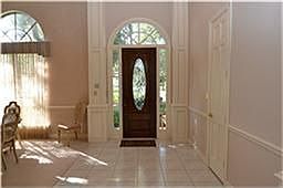 Entry offering a beveled glass front door, tile flooring, raised ceilings, chair rails and double cr