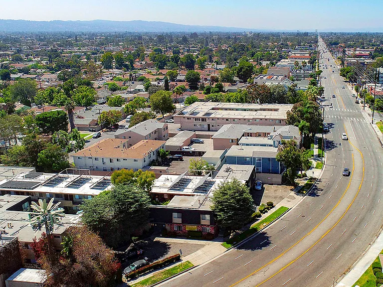 Aerial drone photo of 10620 NoHo showing solar panels and energy-efficient white roofing.