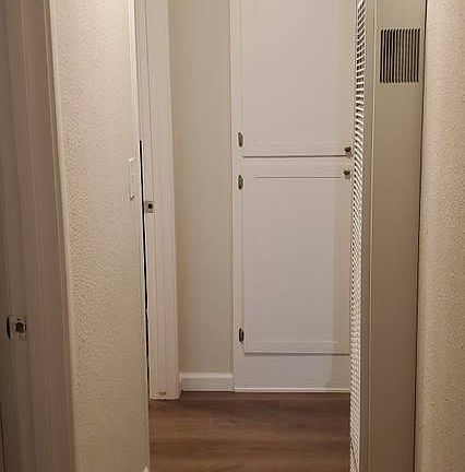 Hallway with additional closet storage leads to bathroom and bedrooms.