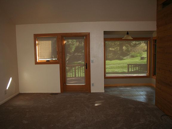 Living Room and eat-in area overlooking the backyard and deck. Ceiling fan in living room.