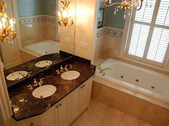 The marble master bath features double sinks, jetted tub, and glass shower