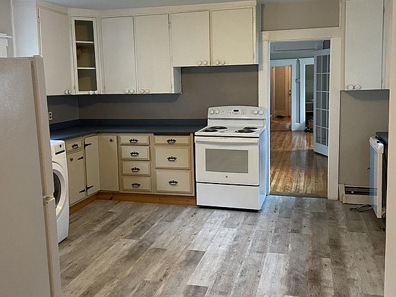 Kitchen, view 2; view from full bath, plenty of cabinet space, new stove, dishwasher and flooring, fresh coat of paint.
