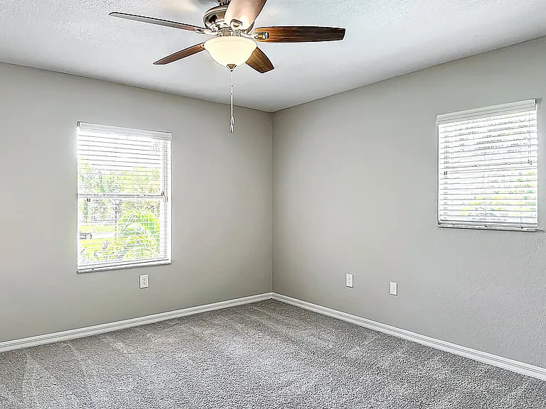 Spacious bedrooms with plush carpeting, neutral walls, and large windows providing ample natural light, perfect for creating a cozy retreat.