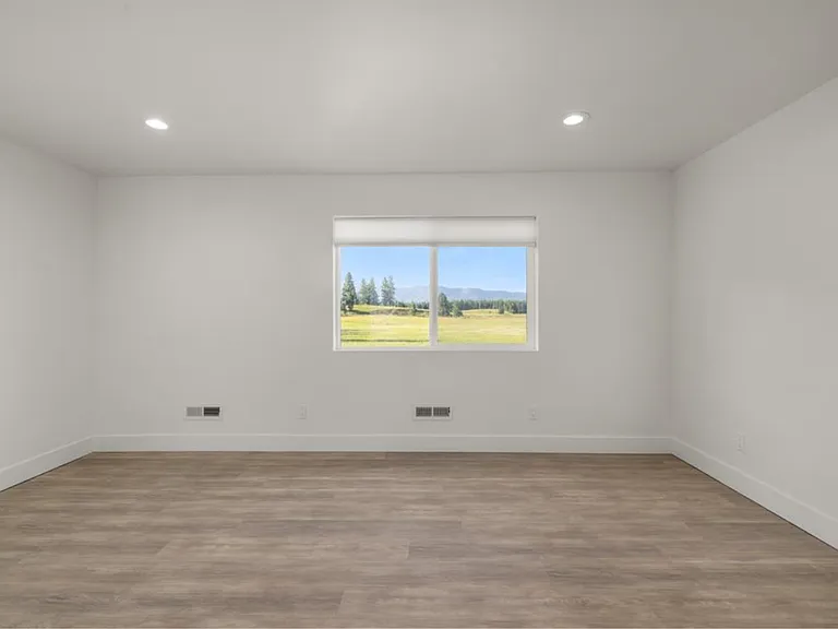 Private second-floor suite showcasing unobstructed mountain range views, creating a peaceful retreat filled with natural beauty and Montana serenity. Shown unfurnished to highlight the spacious layout and versatility of the space.