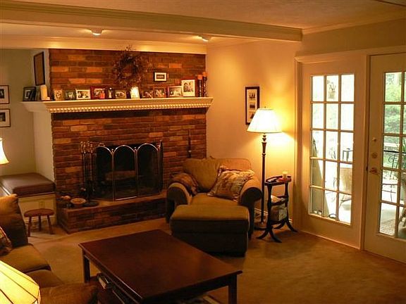 Family room with wood fireplace and french doors to screened porch.