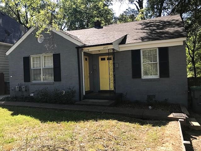 Freshly painted brick duplex. Each side has fenced yard and driveway.