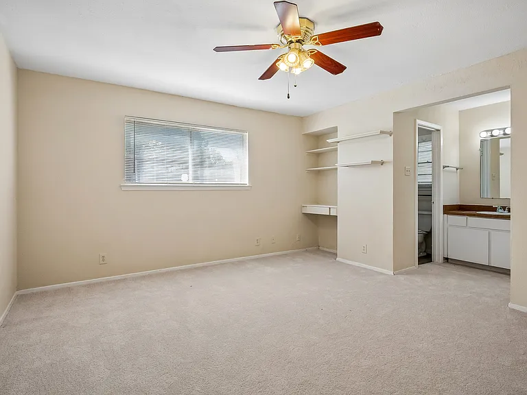 Primary bedroom with built-in shelves and an ensuite bath & walk-in closet