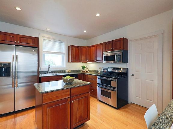 Kitchen with island, stainless steel refrigerator, microwave, dishwasher, stove, and office nook