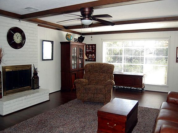 Spacious family room with a wood burning fireplace and exposed beam ceiling.