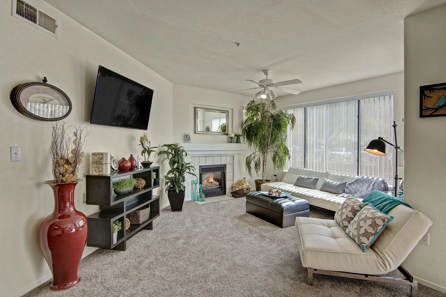 Living room with fireplace, television, sofa, and decorative items.