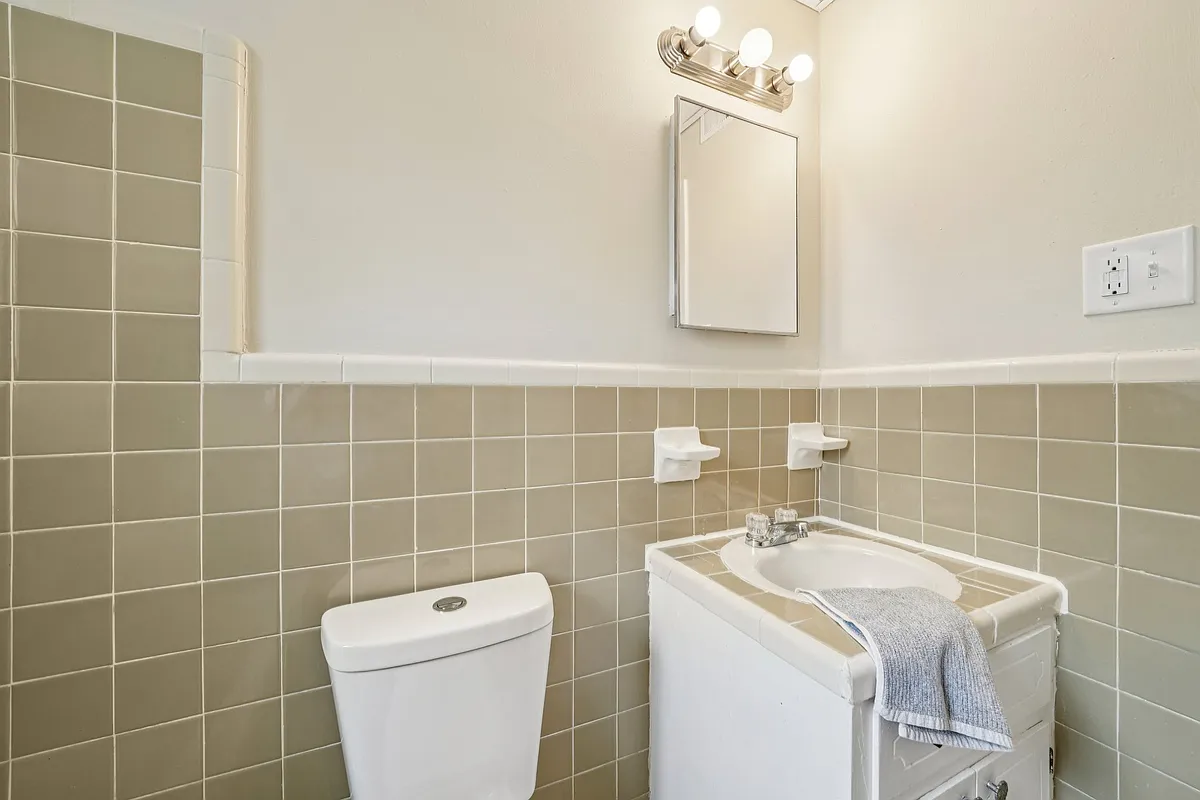 Full size tube, shower, with the charm of original tile, sink, toilet, and medicine cabinet with shelves. - Fox Valley Apartments