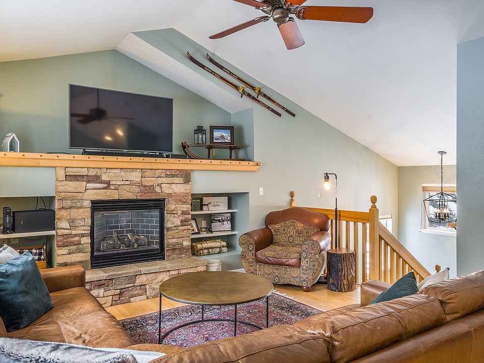 Sunny living room with large windows, vaulted ceilings, fireplace, and great views. Large Smart TV, sound bar. This is open to the kitchen + dining room.