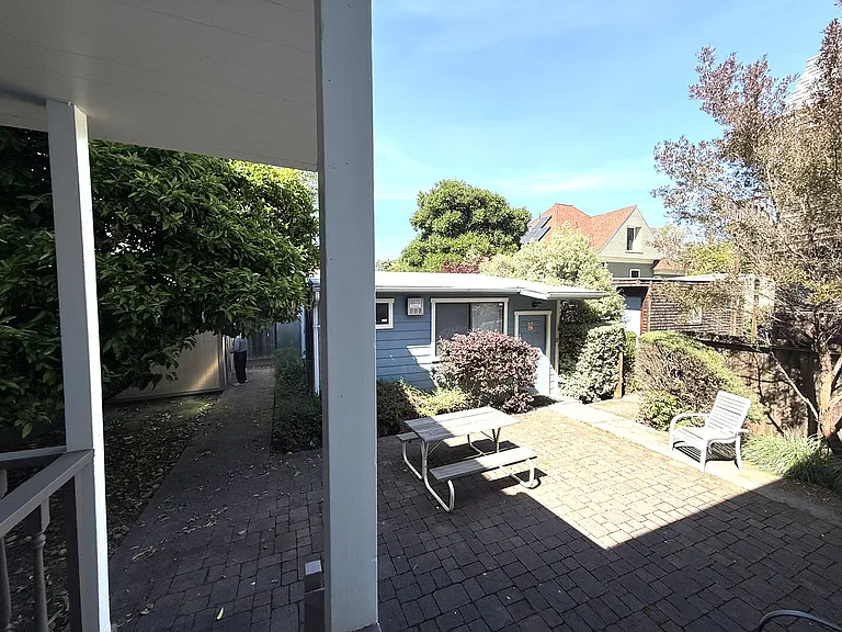 Looking into the backyard from the porch off the kitchen (rear structure not included in rental)
