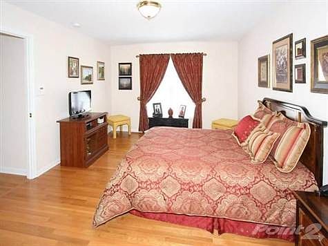 Owner's suite with hardwood floors and adjoining private tiled bath.