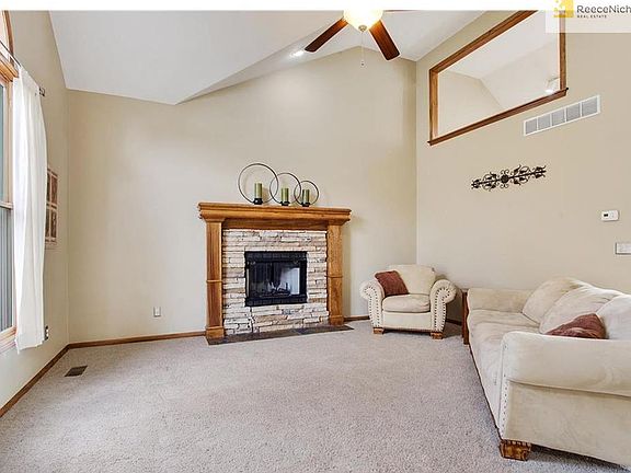 Enter into the light and bright main-level living room with fireplace and vaulted ceilings