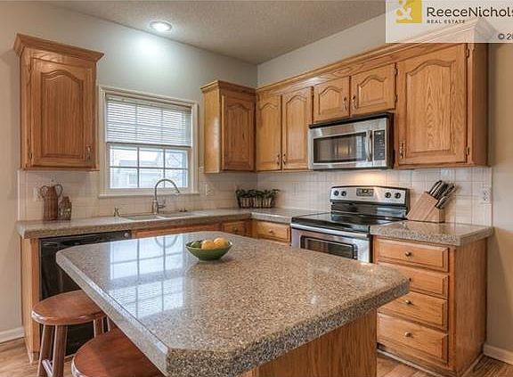 Close up of the serving island, smooth top stove and microwave.  New brushed nickel hardware and garbage disposal.