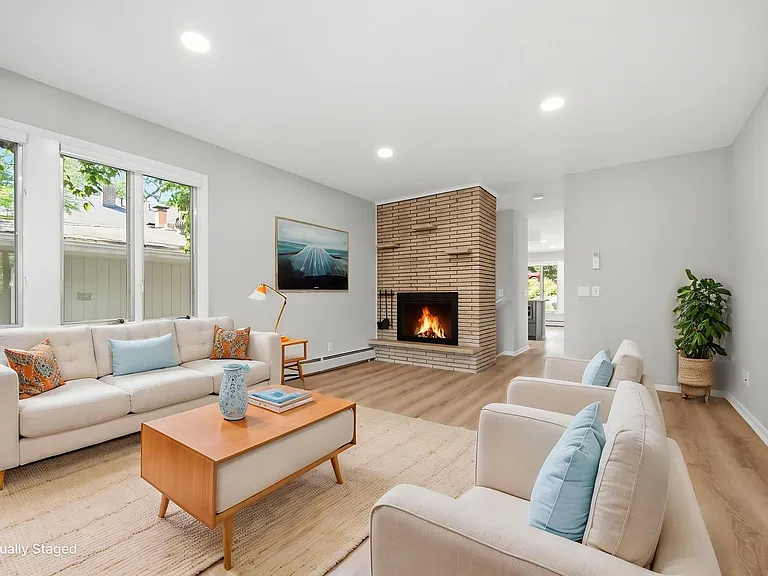 Front living room with fireplace and wall of front and side windows overlooking Lake Harriet and bandshell (seasonally) and gorgeous front yard