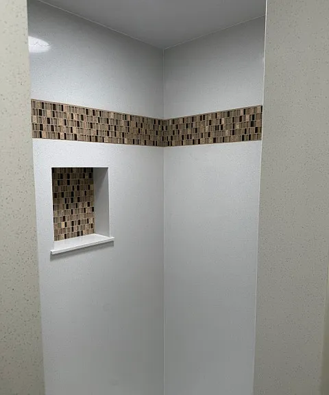 New Quartz solid surface shower with deco accent.