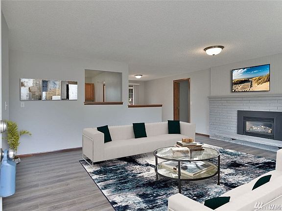 Welcome home to this lovely Lynnwood rambler. Bright and open living room centered around a cozy gas burning fireplace. Opens to kitchen and dining area. 