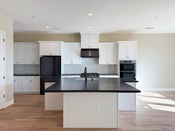 Kitchen boasts built-in appliances, sleek finishes and center kitchen island with an optional extens