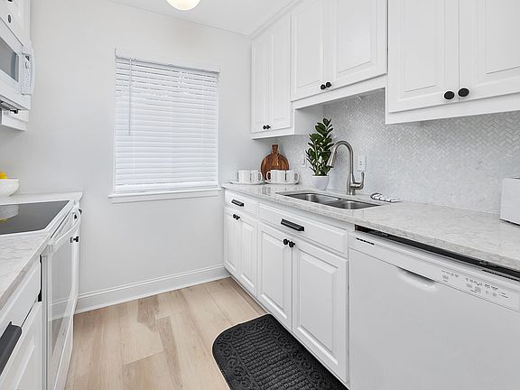 Kitchen with attached laundry closet with full sized washer and dryer.