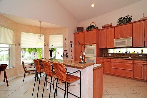 Kitchen With Glazed Wood Cabinetry and Granite Countertops