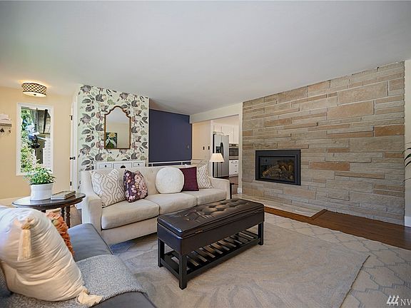 One of three fireplaces, this gas fireplace with stunning stone surround anchors the living room. Enjoy the warmth of the flame on colder nights.