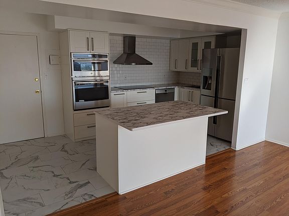 New kitchen with stainless steel appliances, subway tile back splash, and quartz stone counters