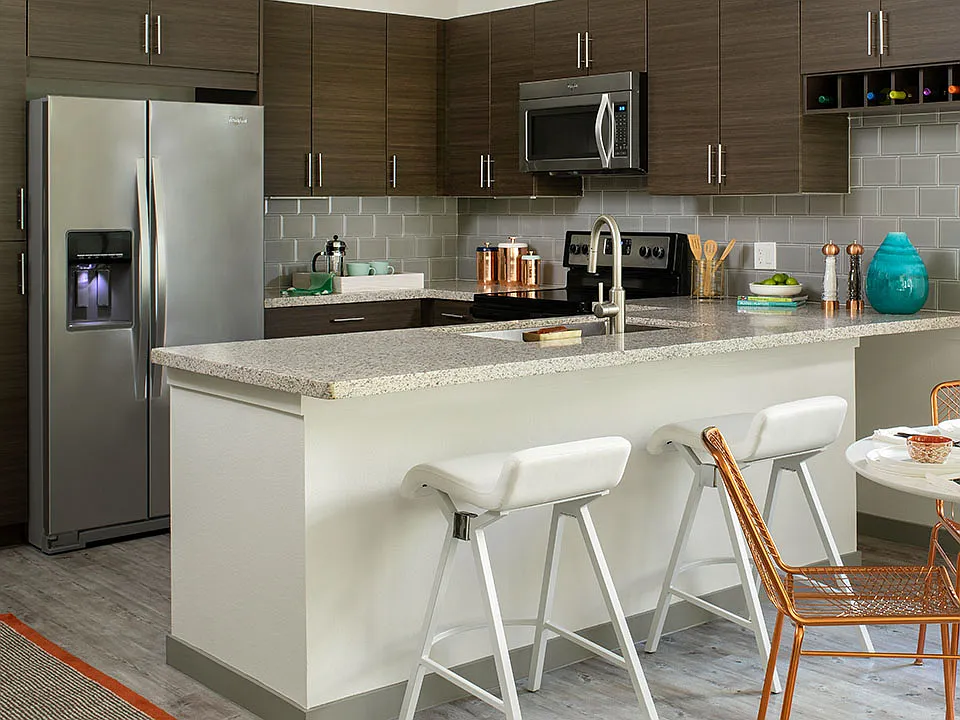 Apartment Kitchen with Stainless Steel Appliances, granite counter top and hardwood flooring.